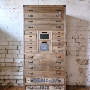 A tall wooden apothecary style cabinet with drawers - Cambrewood